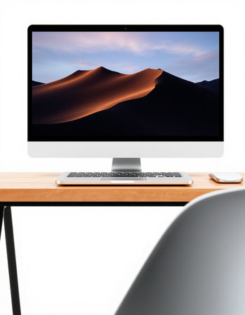 Modern workplace with computer on wooden table and blurred image of sand dune