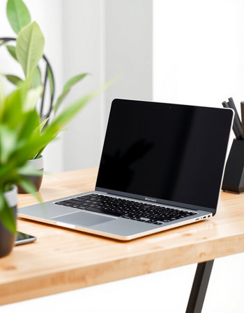 Laptop with blank screen on wooden table in office. Mock upの写真素材