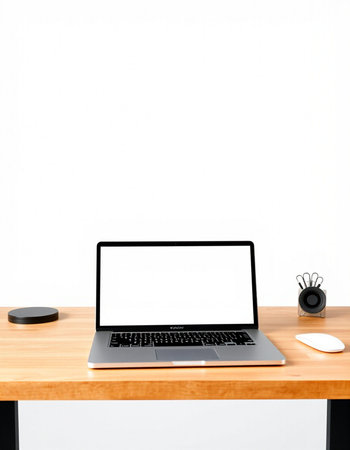 Laptop computer with blank screen on wooden table and white wall background