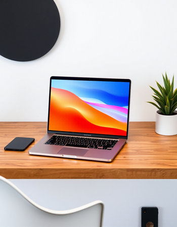 Laptop on wooden table and white wall background.