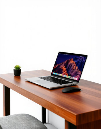 Laptop on a wooden desk with a white wall in the background