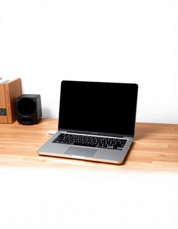 Laptop on a wooden desk with a speakerの写真素材