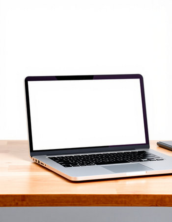 Laptop with blank screen on wood table and white wall background.