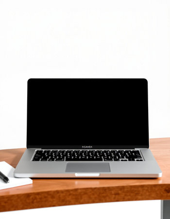 Laptop with blank screen on wood table and white wall background.