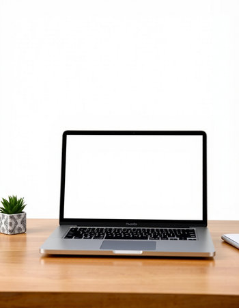 Laptop with blank screen on wooden table and white wall background.
