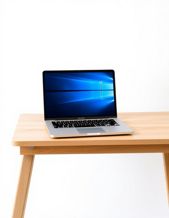 Laptop with blue screen on wooden table isolated on white background.の写真素材