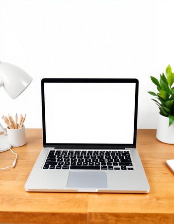 Laptop computer with blank screen on wooden table and white wall background