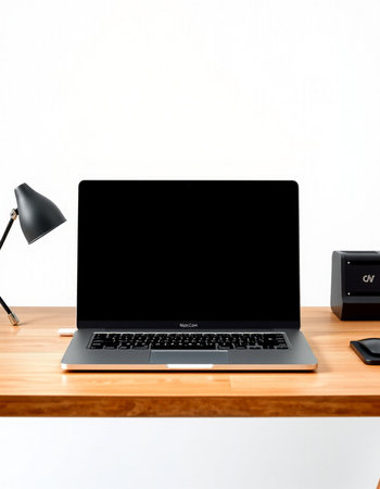laptop with blank screen on wooden table and lamp on white wall background