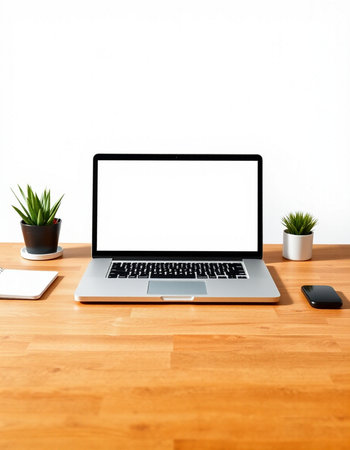 Laptop computer with blank screen on wood table and white wall background