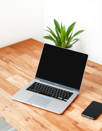 Laptop with blank screen on wooden table in modern office. Mock up
