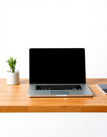 Laptop computer on wooden table with white wall background, stock photo
