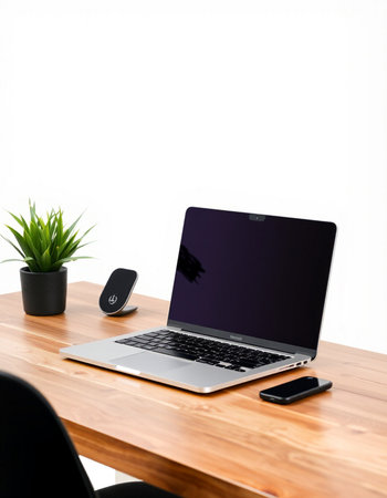 Laptop with blank screen on the wooden table and white wall background