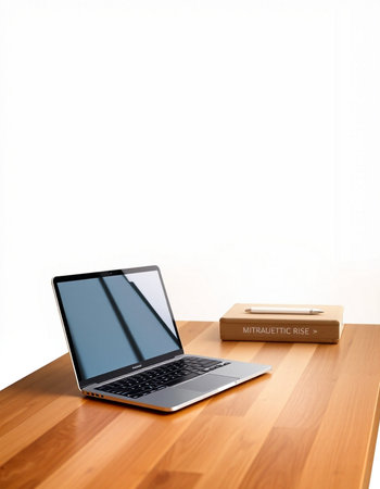 Laptop on the wooden table with white wall background