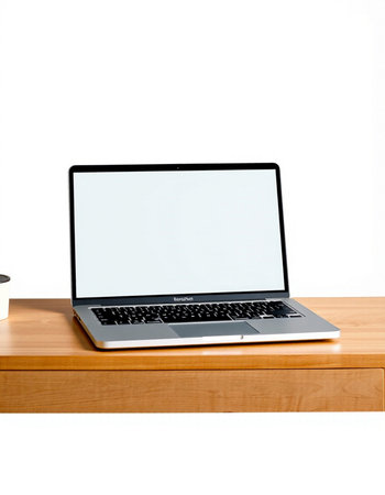 Laptop with blank screen on wooden table isolated on white background.