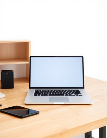 Laptop and smart phone on wood desk with white wall background.