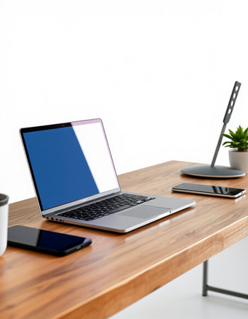 Modern workspace with blank screen laptop, smartphone and coffee cup on wood table.の写真素材