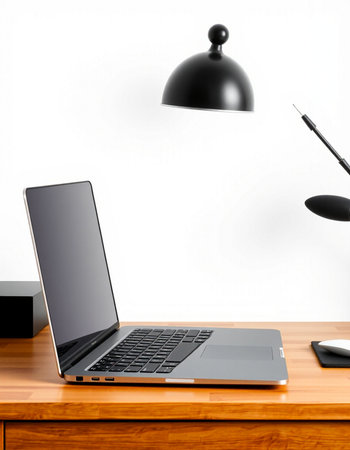 Laptop on a wooden table with a lamp on a white background