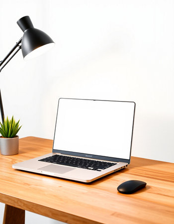 Laptop with blank screen on wooden table and lamp on white wall background