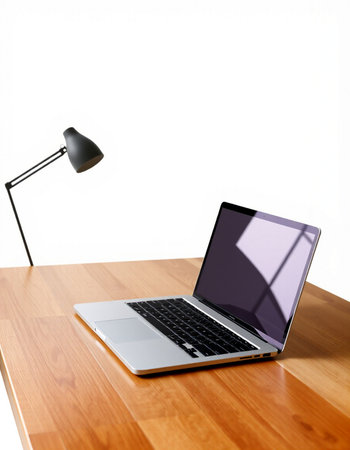 Laptop on a wooden desk with a lamp and a white background