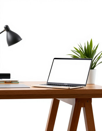 Laptop with blank screen on wooden table and white wall background.