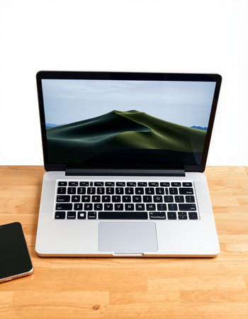 Laptop on a wooden desk with a view of a mountain landscape