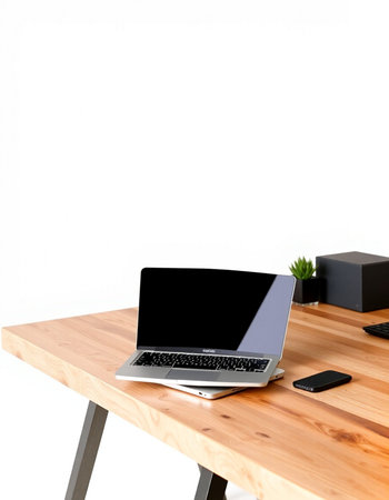 Laptop computer with blank screen on wooden desk and white wall background
