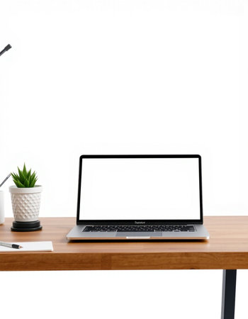Laptop with blank screen on wooden table with white wall background.
