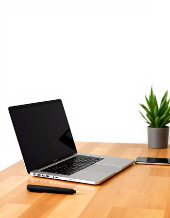 Laptop on a desk with a pen and a plant on a white background