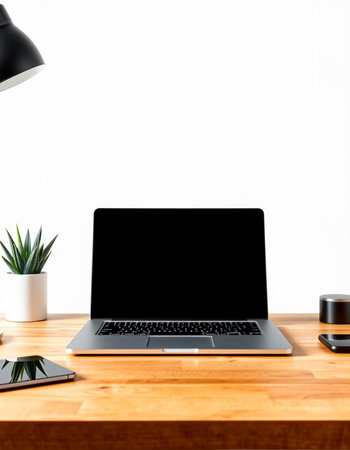 Laptop with blank screen on wooden desk with coffee cup and plant