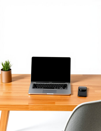 Laptop with blank screen on wooden table and white wall background.