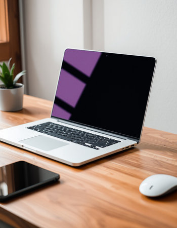 Laptop with blank screen on wooden table in office, stock photoの写真素材