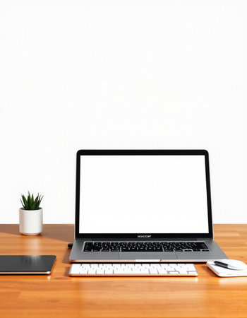 Laptop with blank screen on wooden desk and white wall background.