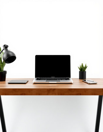 Laptop with blank screen on wooden table and white wall background.