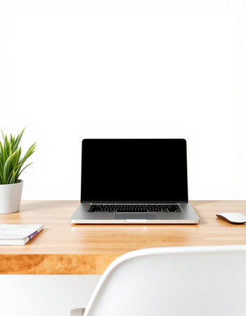 Laptop with blank screen on wooden table and white wall background.