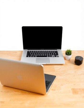 Laptop with blank screen on wooden desk isolated on white background.