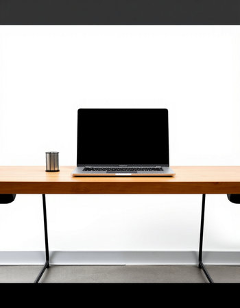Laptop with blank screen on wooden desk in the office, stock photo