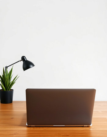 Laptop on the wooden desk with white wall background, stock photo