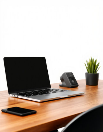 Laptop computer with black screen on wooden table and white wall background