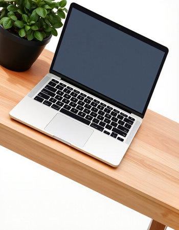 Laptop with blank screen on wooden table in office, stock photoの写真素材
