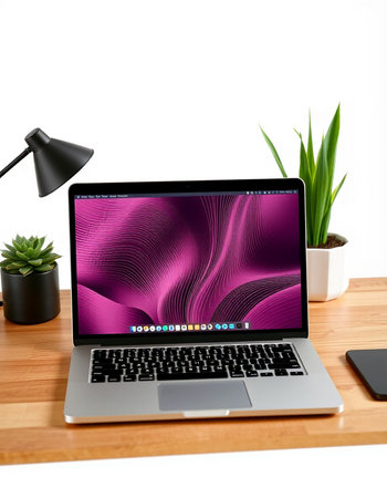 Laptop on wood desk with blank screen.