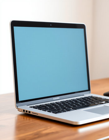 Laptop computer with blank blue screen on wooden table, stock photoの写真素材