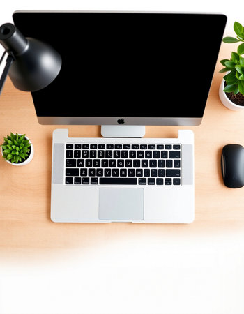 Office workplace with computer, mouse, lamp and plant on wooden table
