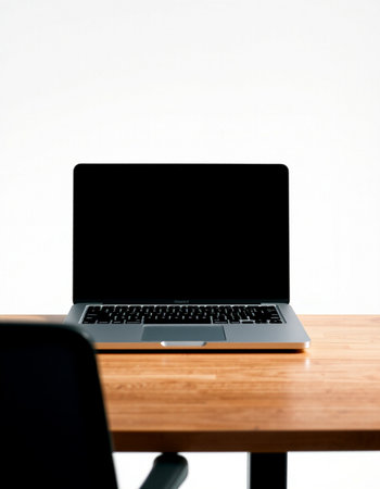 Laptop with blank screen on wooden table and white wall background.の写真素材