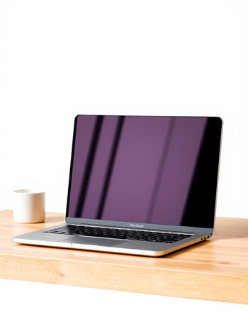 Laptop on a wooden shelf with a coffee cup on a white background