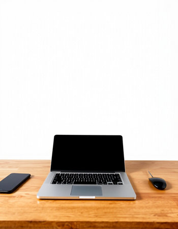 Laptop with blank screen on wooden desk and white wall background.