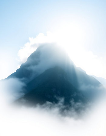 mountain peak in clouds with sunbeams on blue sky backgroundの写真素材