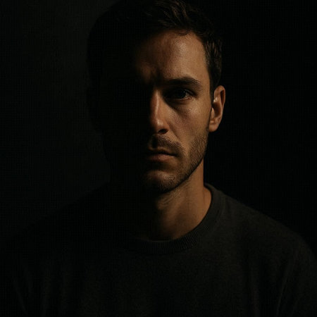 Portrait of a handsome man in a black t-shirt on a dark background