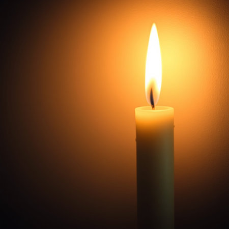 Burning candle on a dark background. Shallow depth of field.