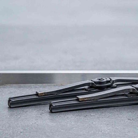 Close-up of a black car windshield wiper on the gray background