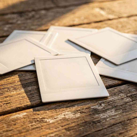 Blank photo frames on a wooden background. Close-up.